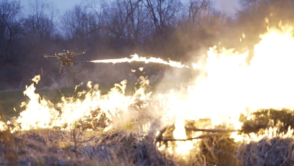 Drone flamethrower burning vegetation