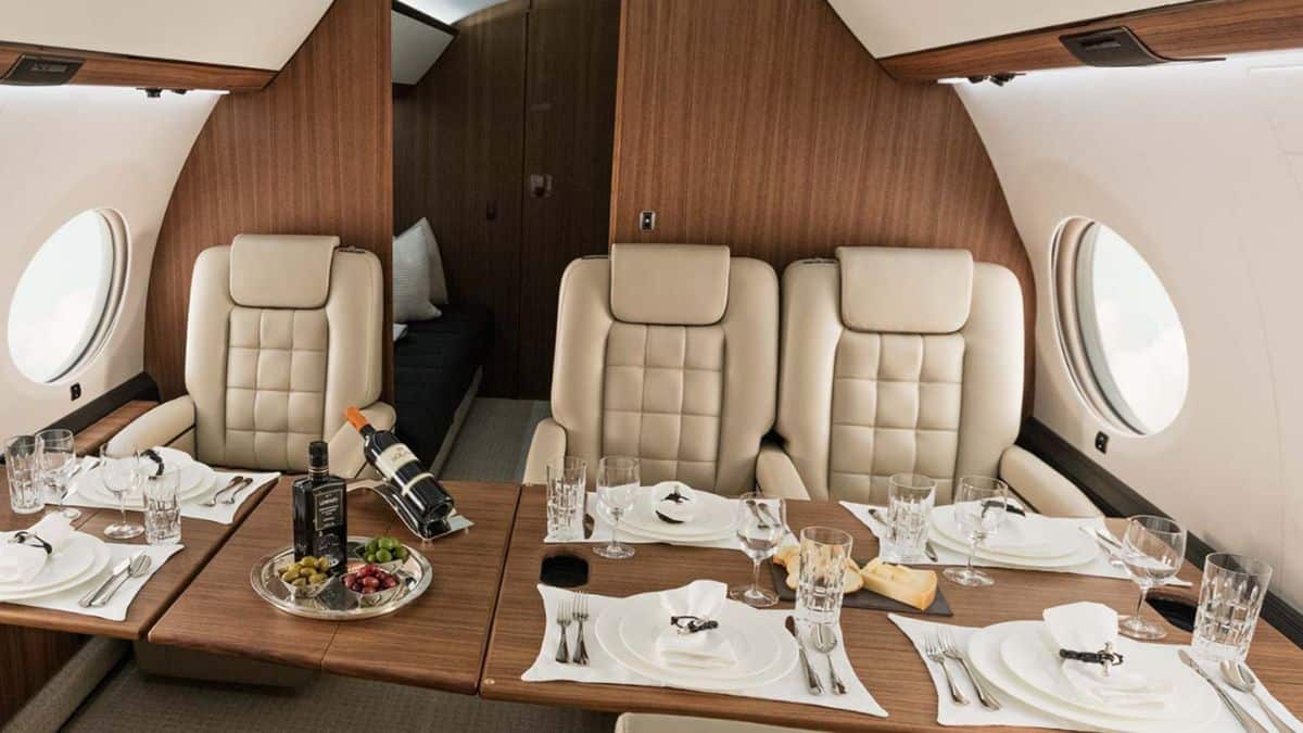 Inside the G650's cabin with its plush seats with a dining setting laid out.