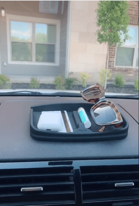 Another Amazon car buy, a non-slip dashboard pat, holds a pair of sunglasses, Airpods, a card and Chapstick.