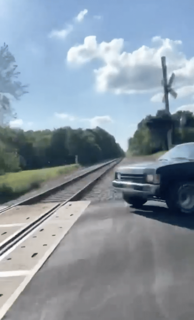 Little Nissan truck gets huge air jumping over train line