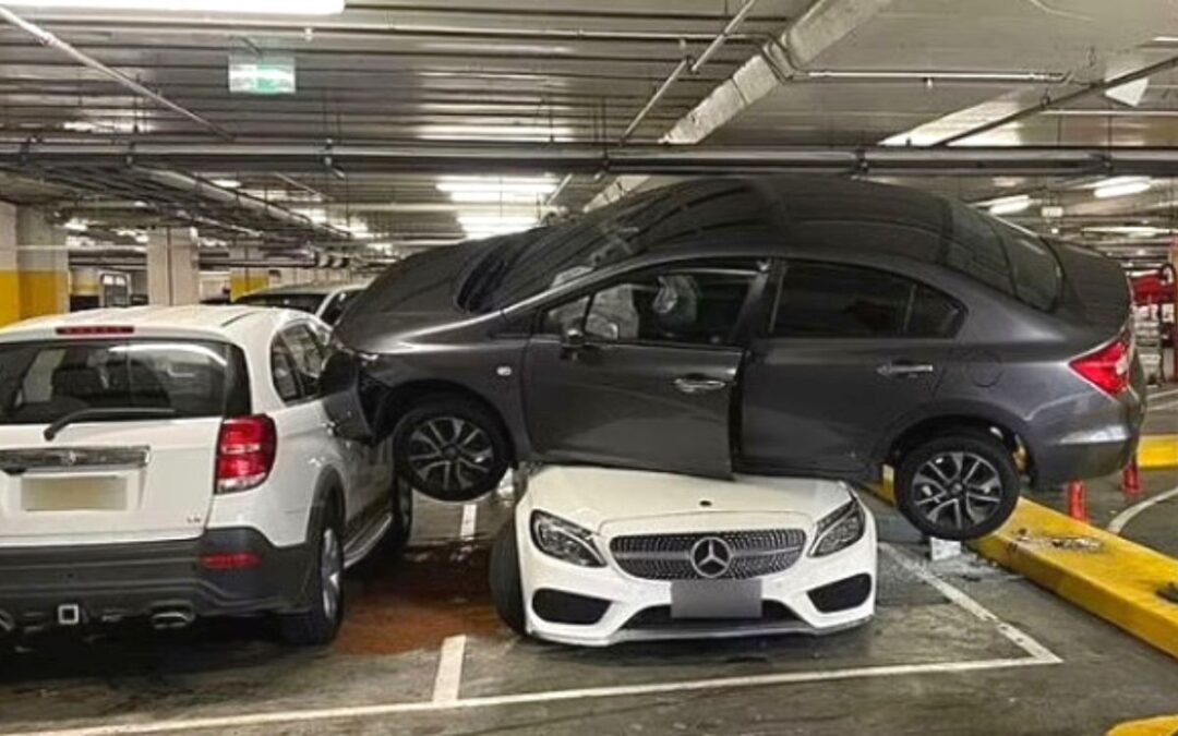 Extreme parking fail: Driver wedges Honda Civic on top of Mercedes in a busy parking lot