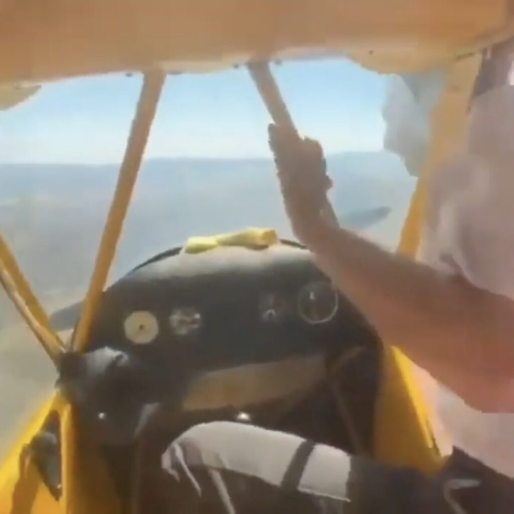 Pilot climbs out of cockpit to spin propeller