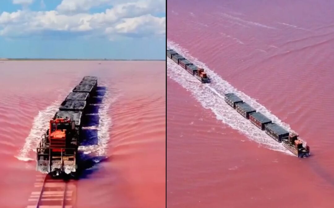 Pink lake in Siberia has a train running through it