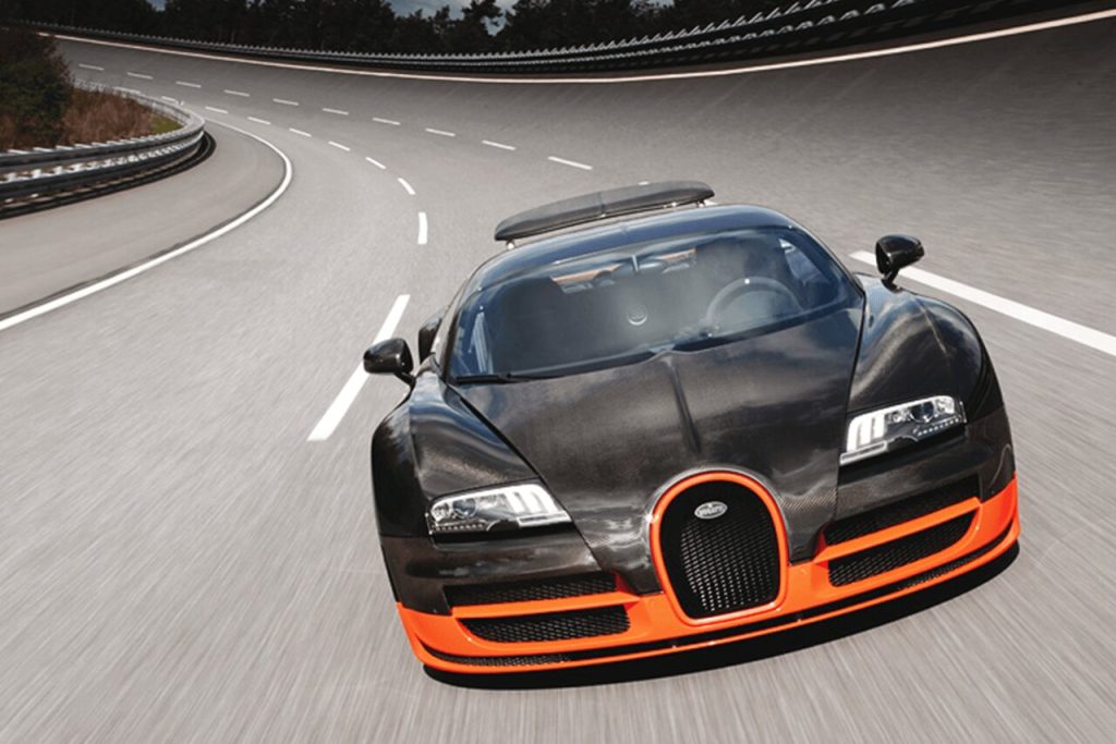 A black and orange Bugatti Veyron SuperSport on a race track.