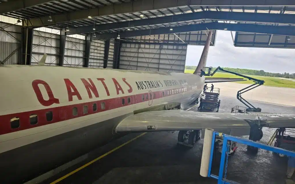 John Travolta's iconic Qantas Boeing 707 has been spotted lying in a parking lot with its tail rotting away.